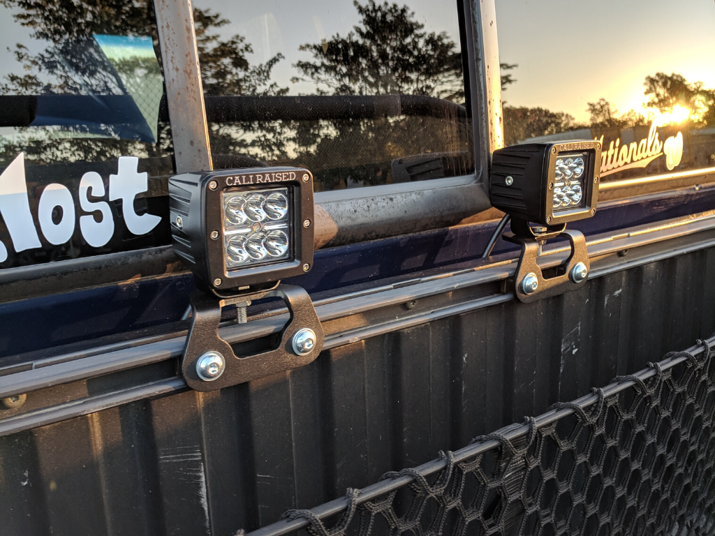 Toyota truck bed rail LED pod lights mounted on metal rails, ideal for overlanding