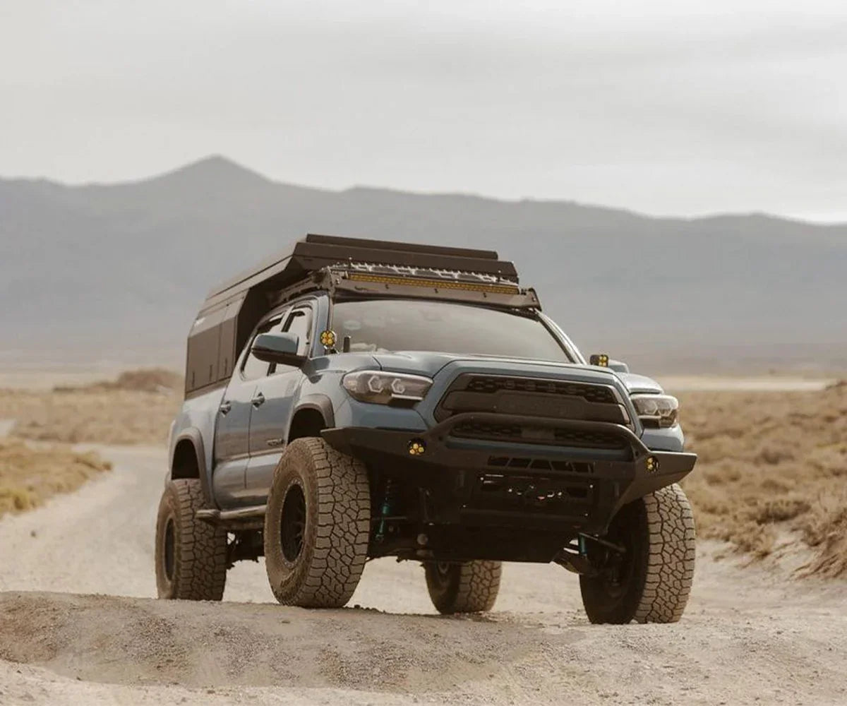 Toyota Tacoma with Prinsu cab rack and overlanding gear on a rugged dirt trail