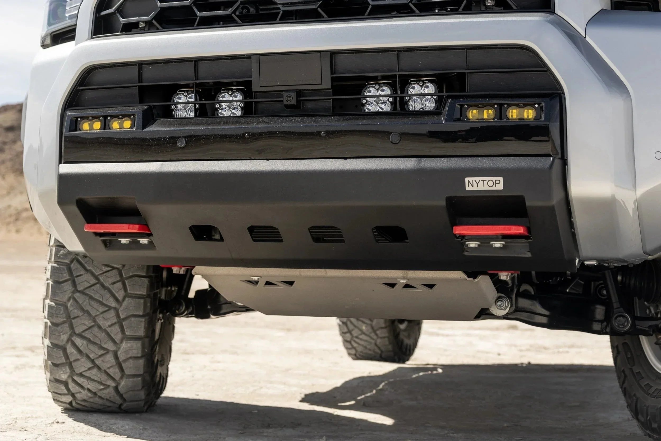 Off-road truck front bumper with skid plate, recovery points, and LED fog lights