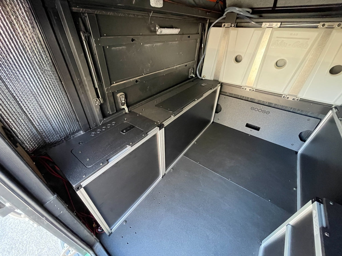 Goose Gear front utility module inside an Alu-Cab canopy camper in a 6-foot Toyota Tacoma bed, interior view