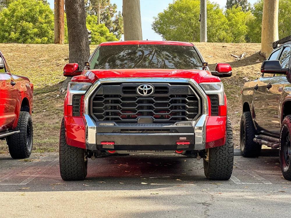 Red Toyota Tundra TRD Pro parked outdoors, front view, off-road tires, adventure vehicle