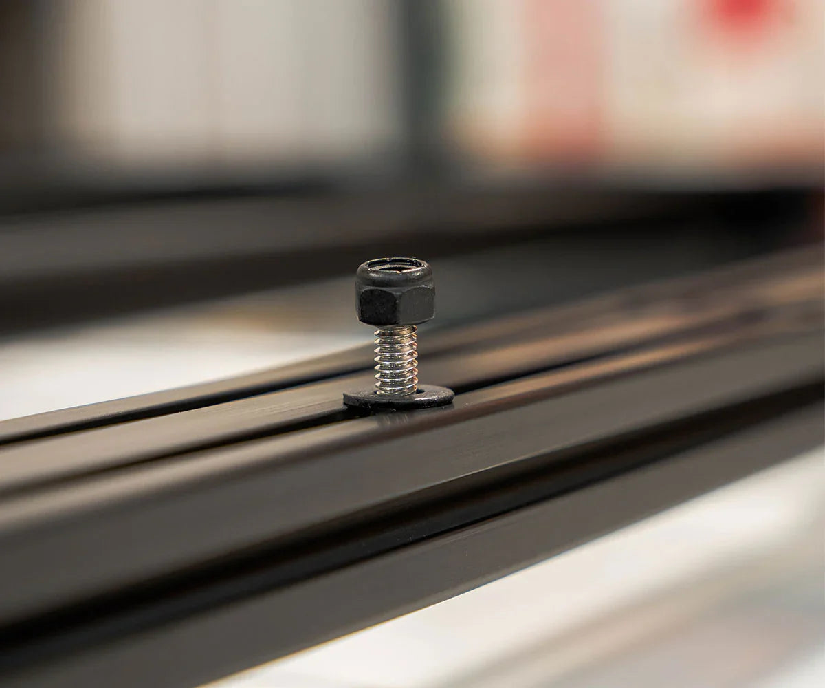Close-up of a hex bolt and washer on a black roof rack crossbar for off-road vehicles