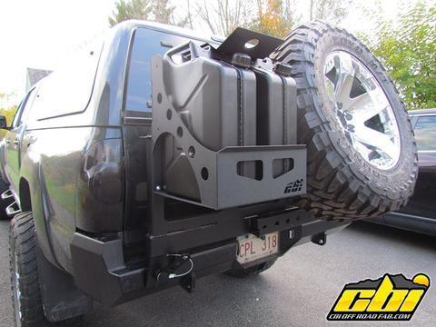 Dual can carrier and spare tire mount on rear bumper of a black off-road truck