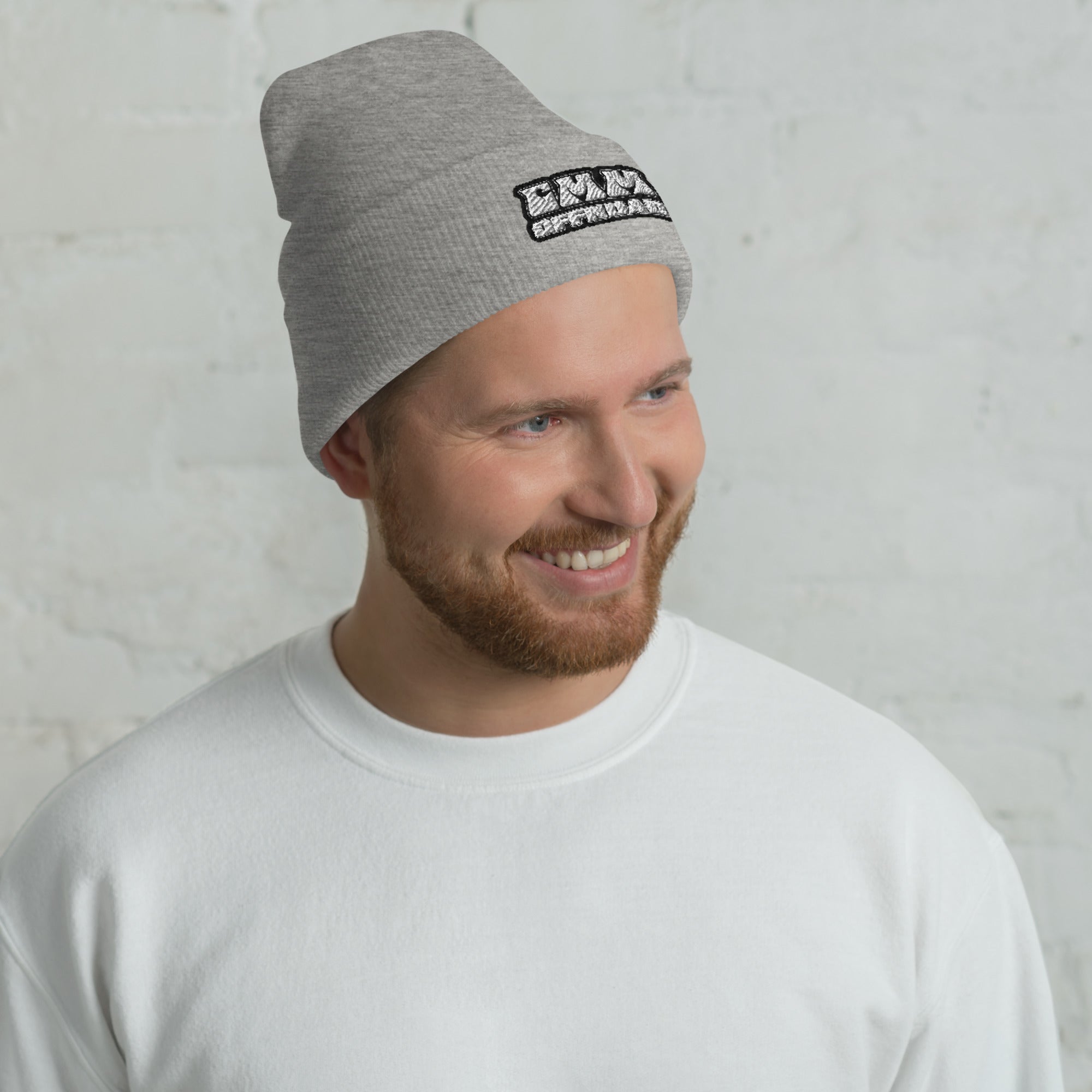 Man wearing a heather grey cuffed beanie with black patch, casual outdoor apparel