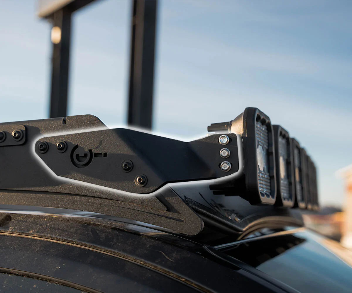 Close-up of black metal roof rack light bar bracket with mounted LED lights on vehicle