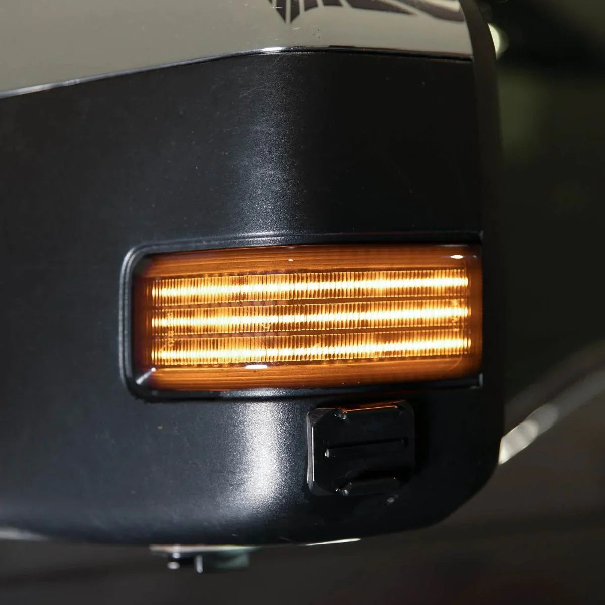 Close-up of 2017 Ford F-250 side mirror amber turn signal light illuminated