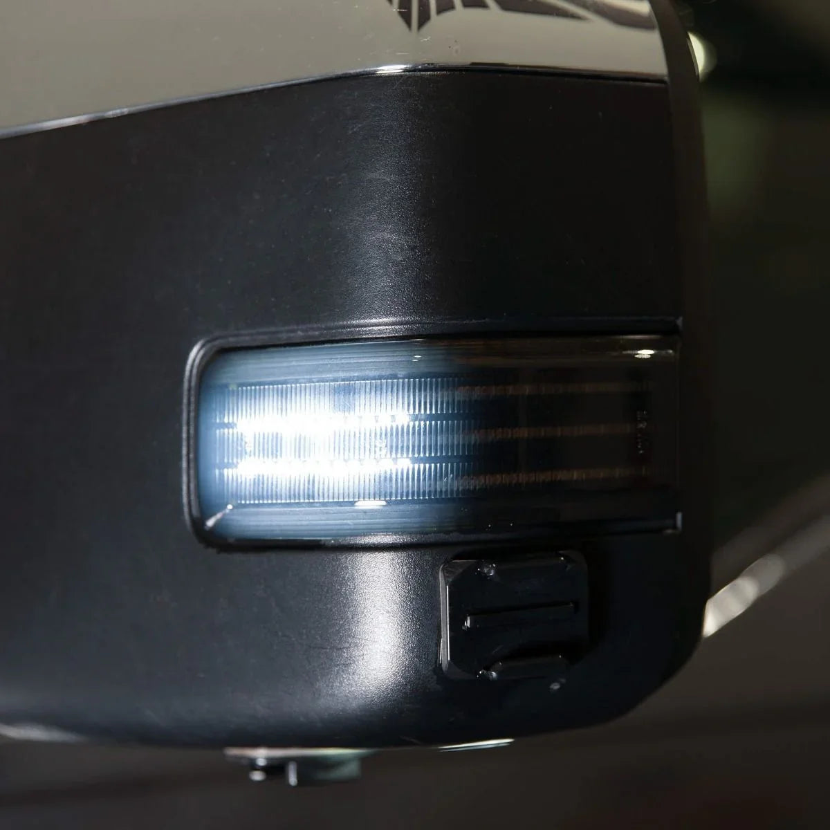 Close-up of Ford F-250 towing mirror with integrated turn signal light illuminated