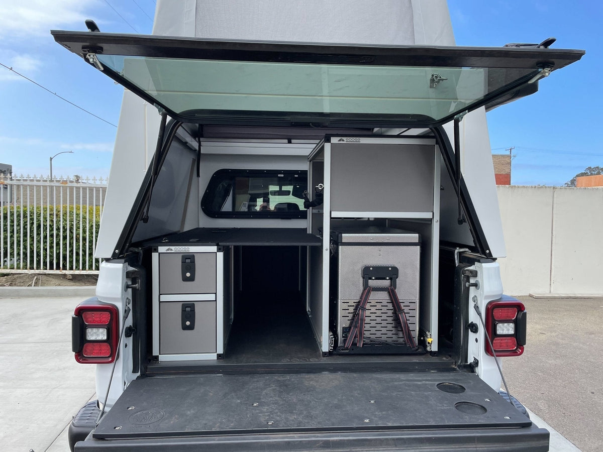 Goose Gear camper system in a Tacoma 6 foot bed, drawer module at left and fridge slide at right under a canopy shell