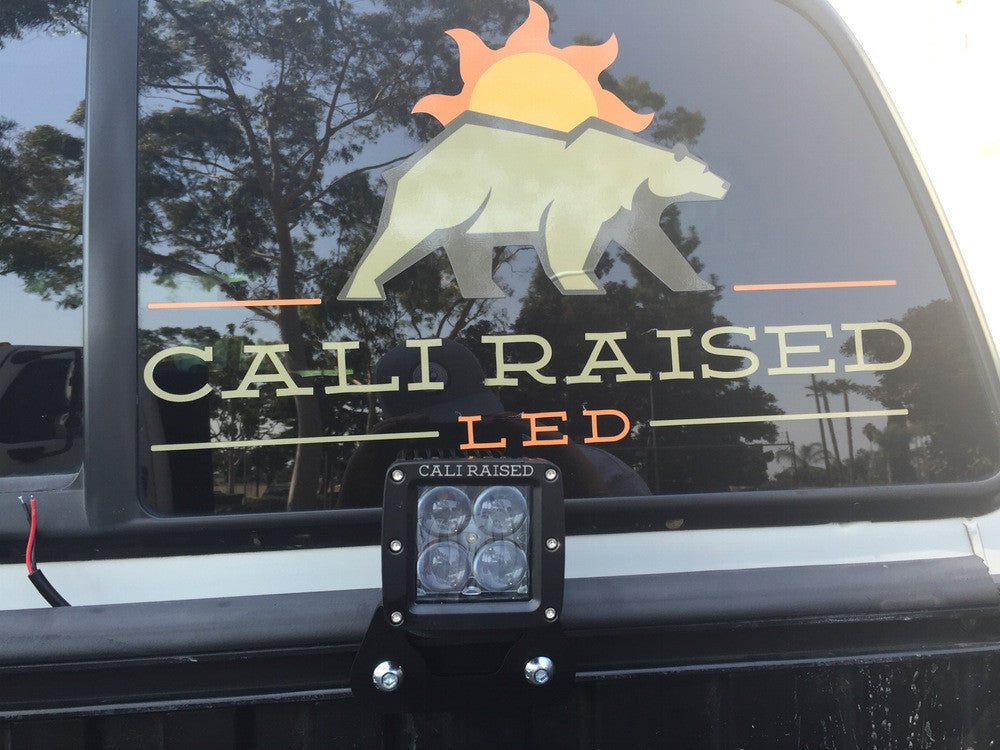 Truck with CALI RAISED LED decal and rear mounted off-road LED light, outdoor setting