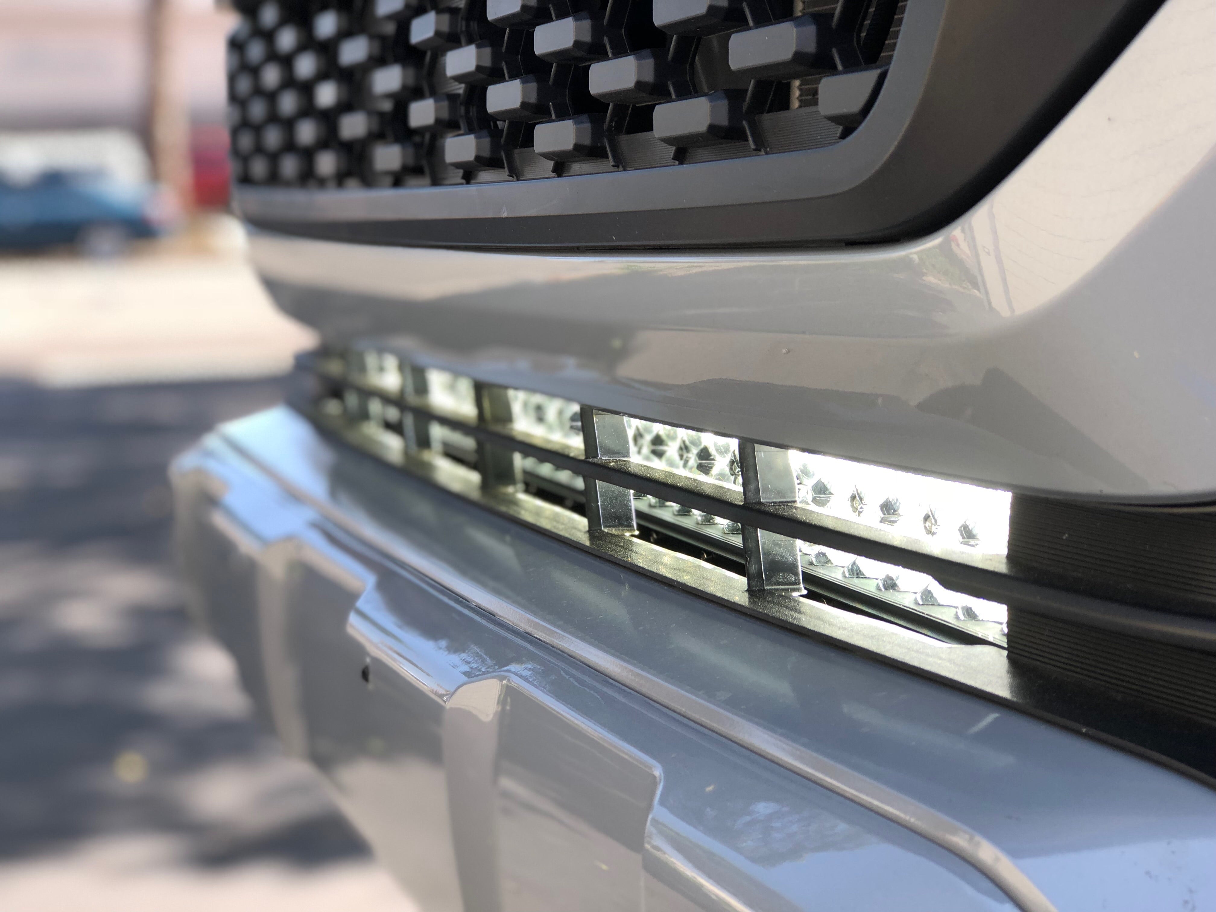 Close-up of off-road LED light bar mounted on a vehicle front bumper grill