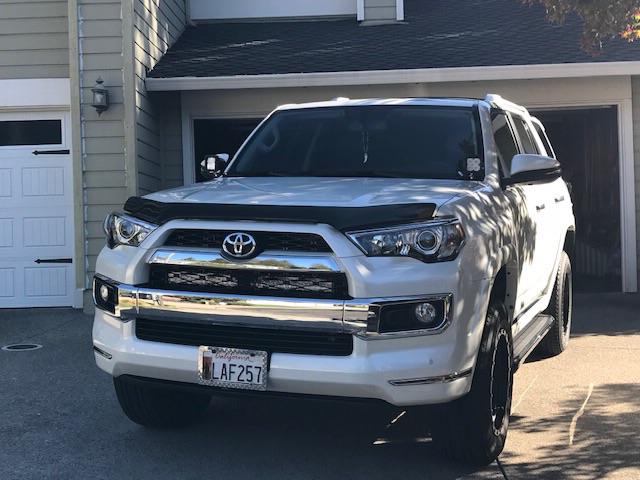 White Toyota 4Runner SUV parked in residential driveway, outfitted for overlanding