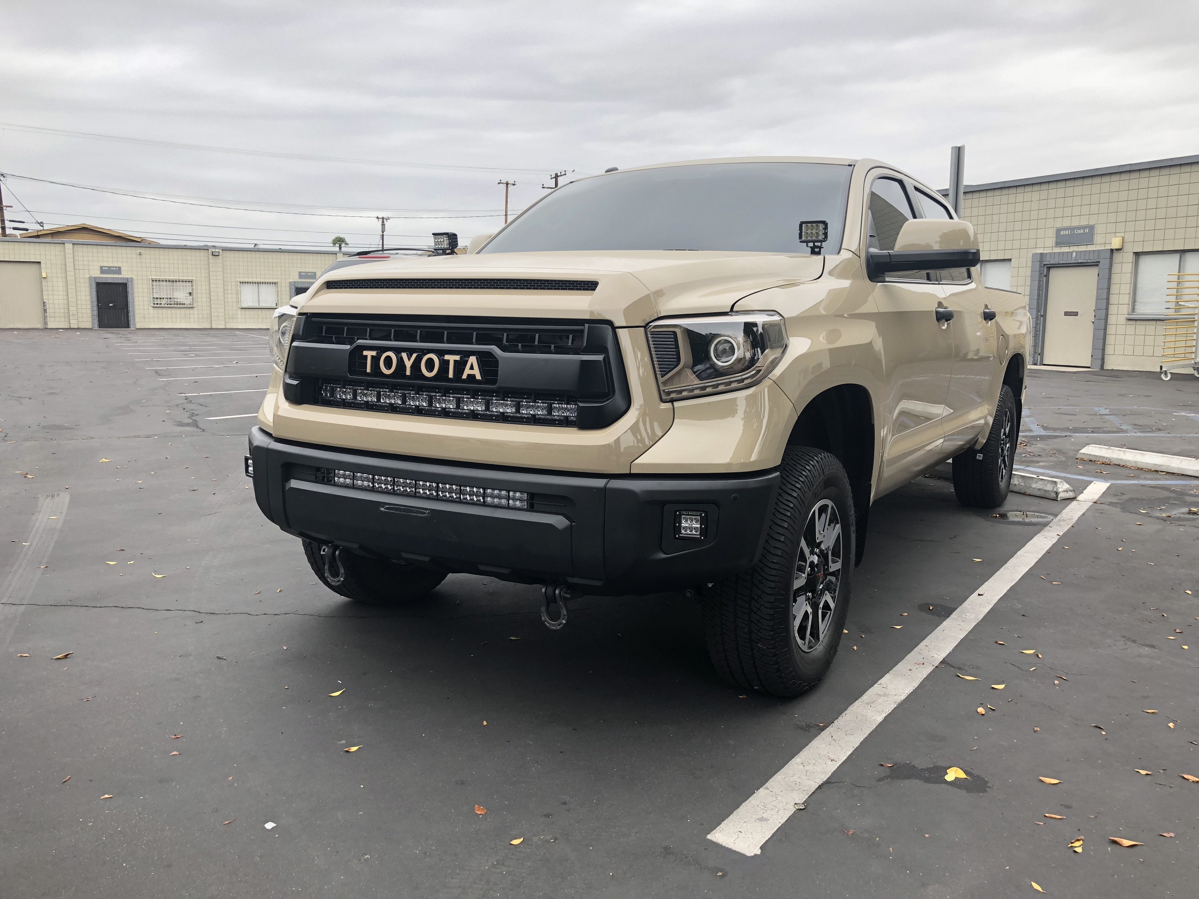 Beige Toyota Tundra with off-road accessories parked in urban lot