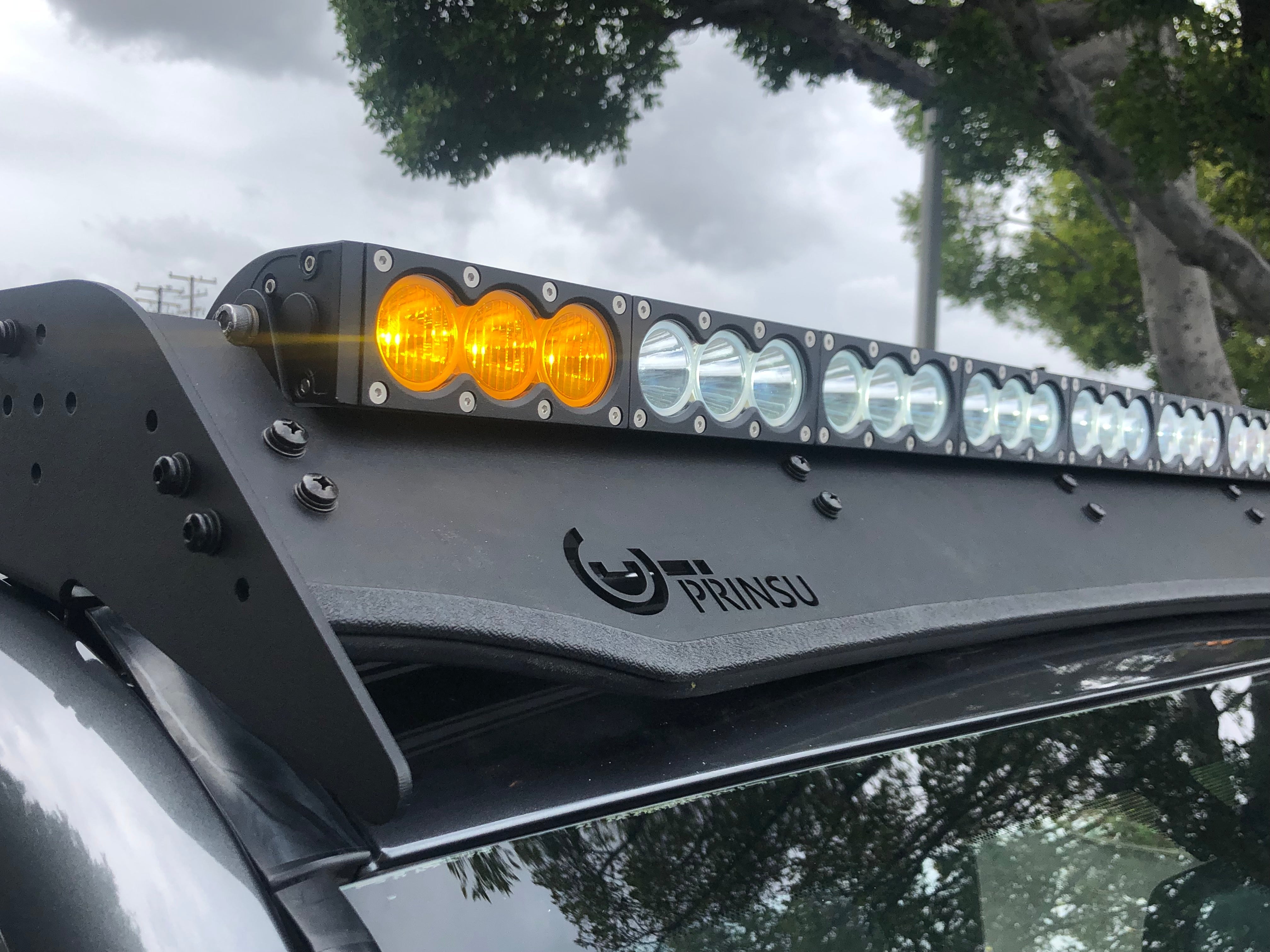Close-up of roof rack with mounted LED light bar on vehicle, outdoor overlanding setup