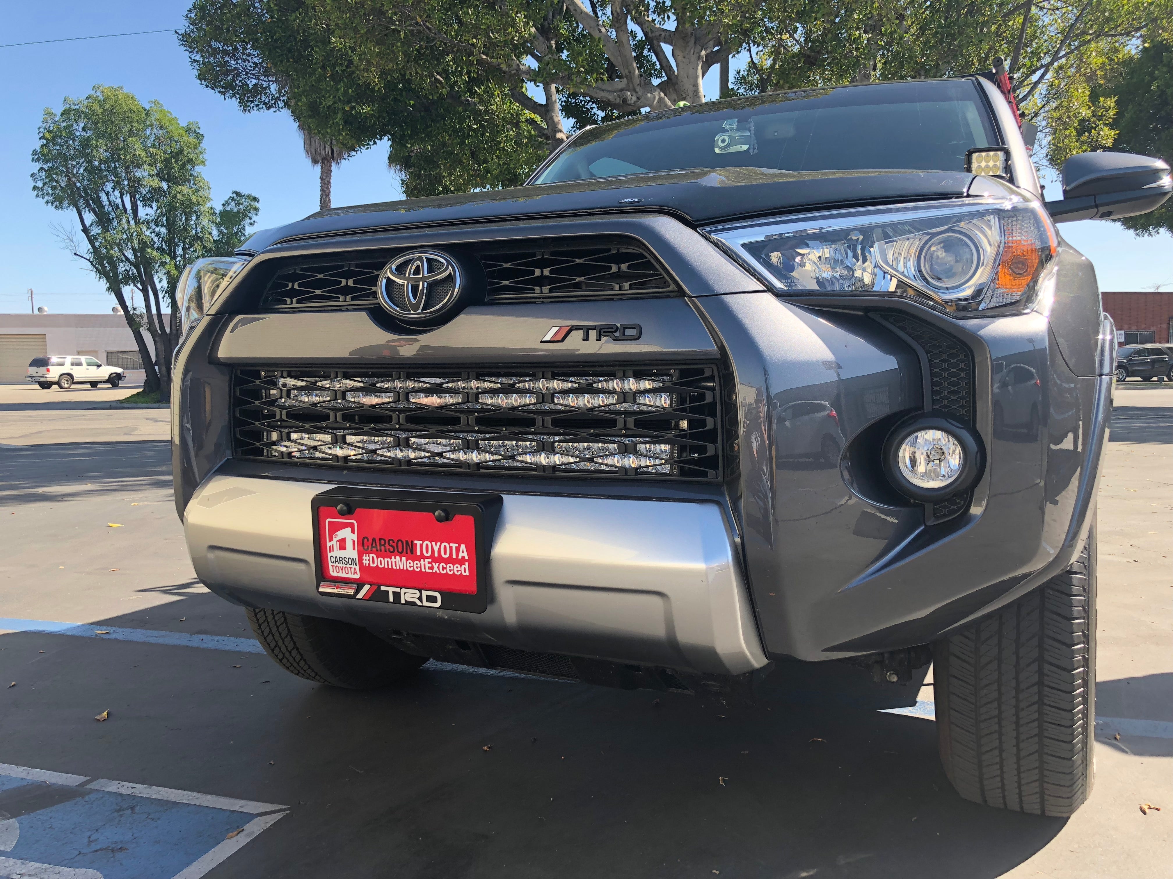 Front view of grey Toyota 4Runner TRD with LED light bar and off-road accessories in parking lot