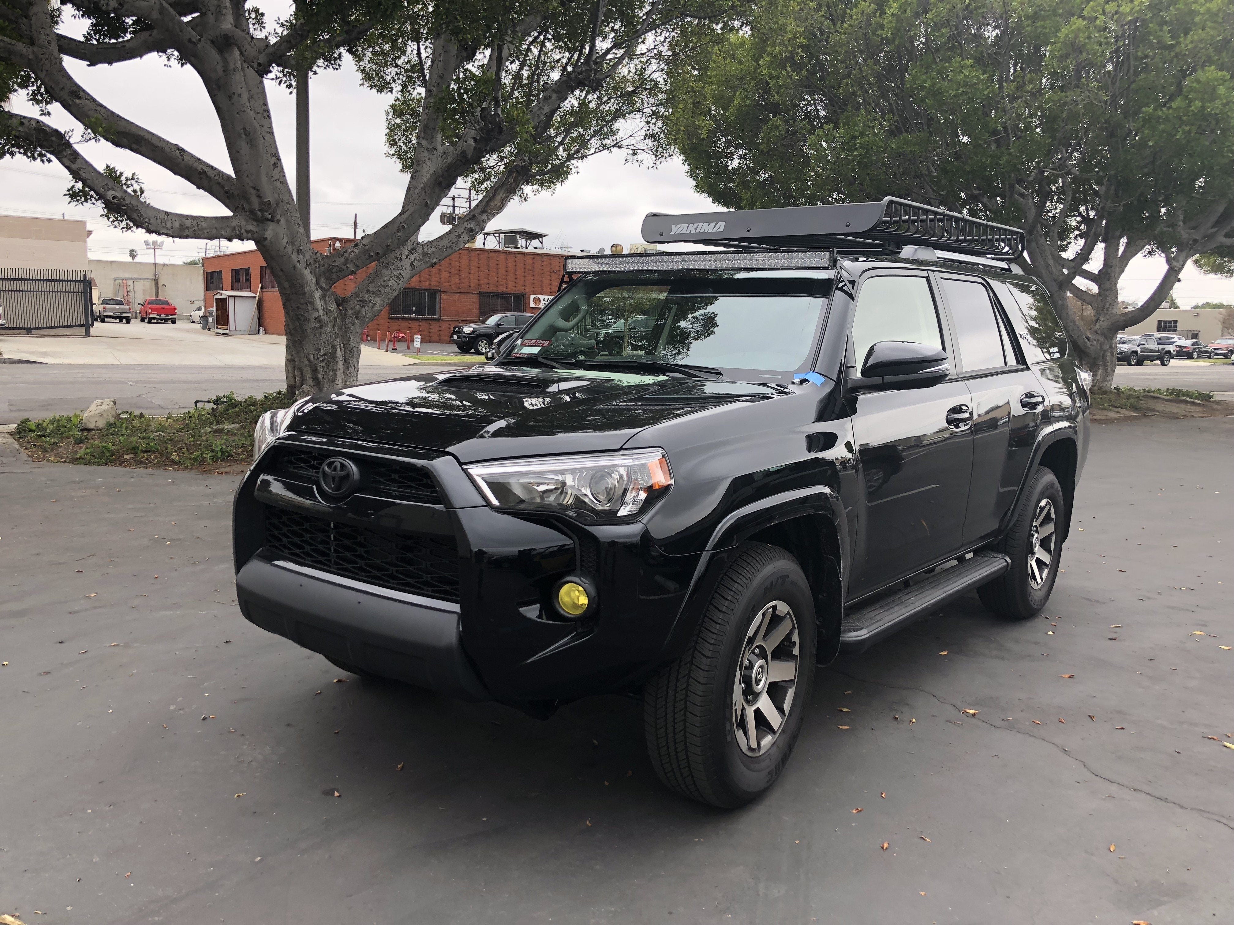 Black Toyota 4Runner SUV with Yakima roof rack parked outdoors, ideal for overlanding.