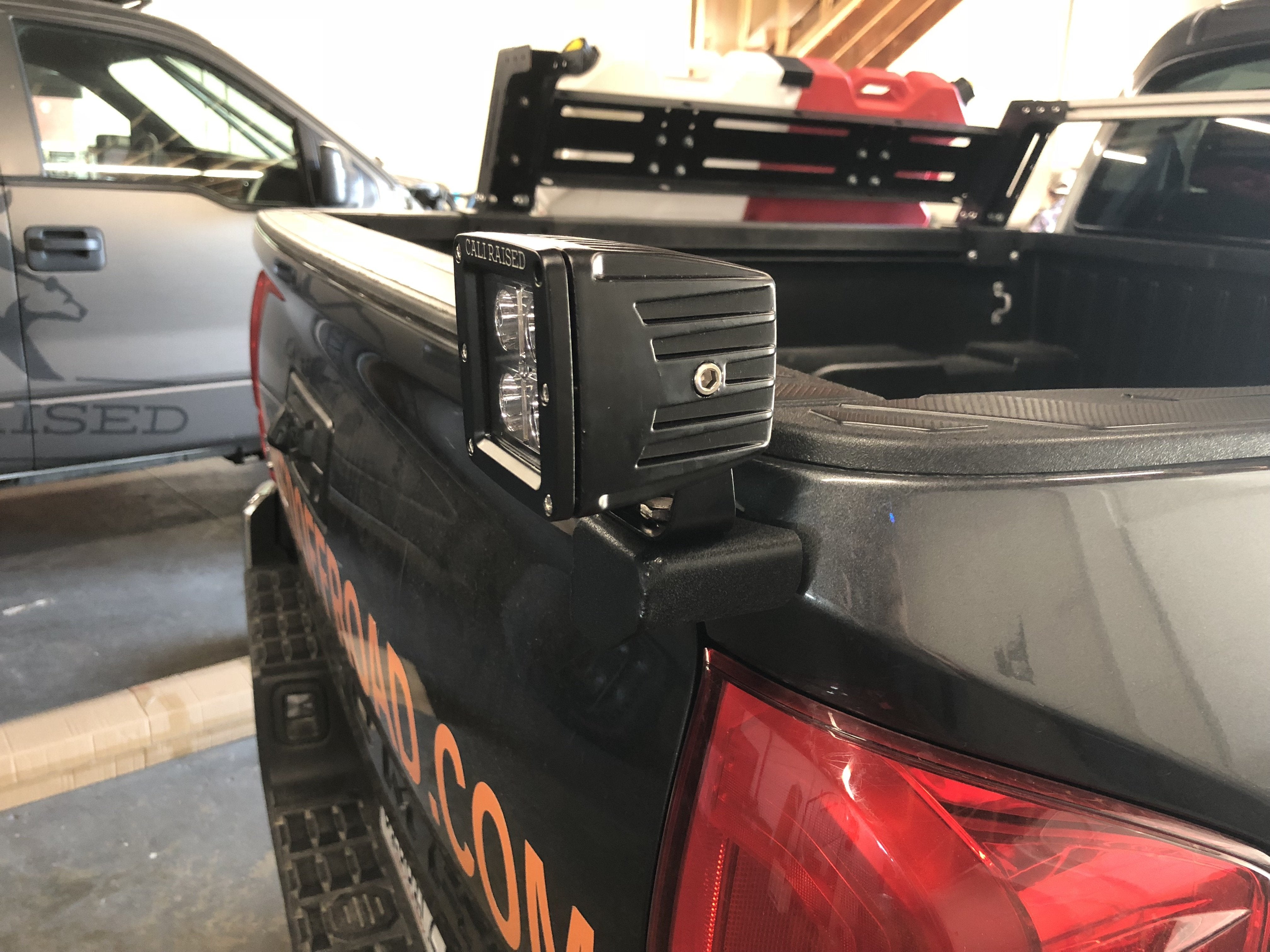 Caliraised LED bed light mounted on a truck bed rail, ideal for overlanding vehicles.