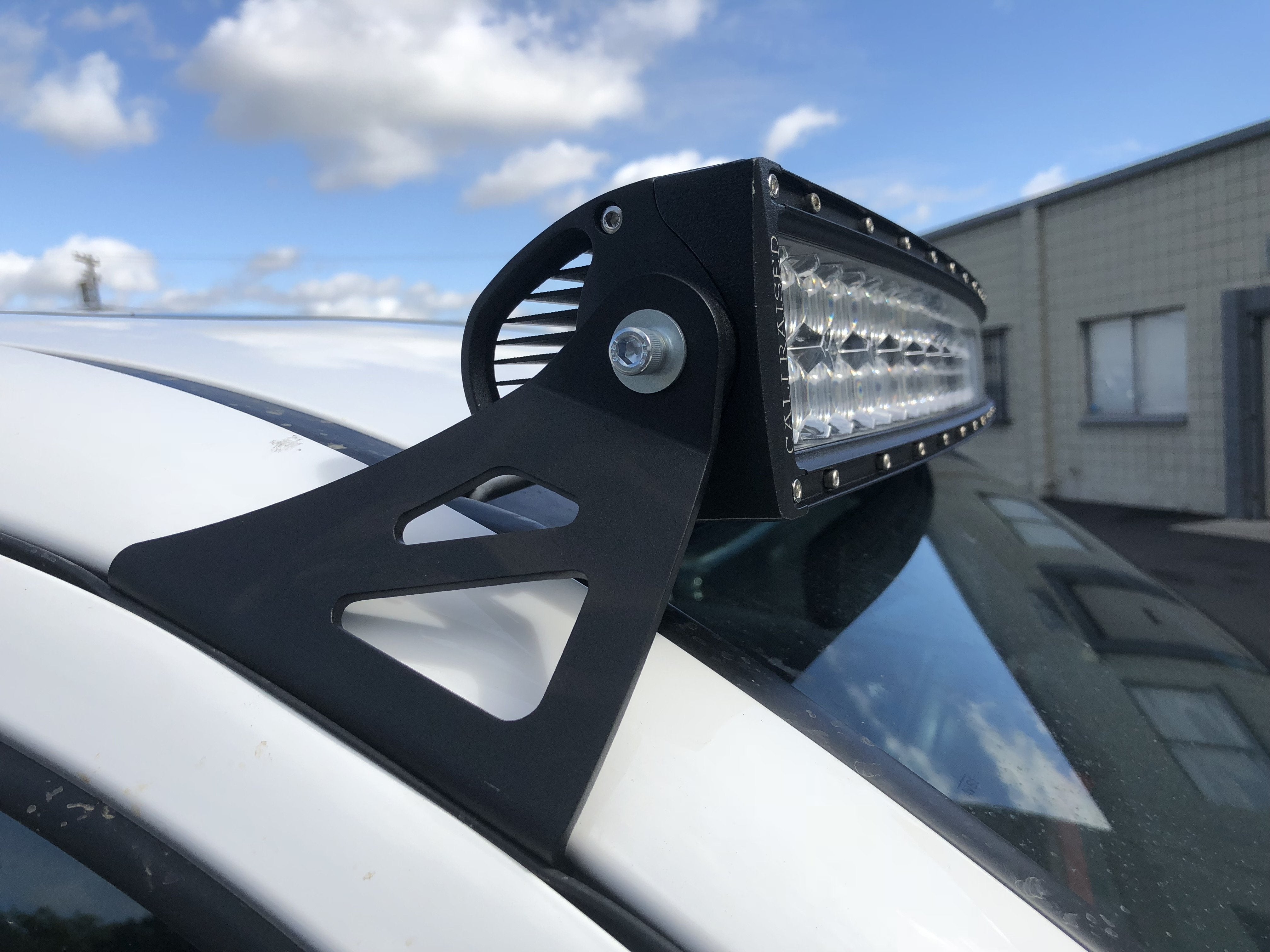 LED roof light bar mounted on vehicle roof rack bracket outdoors