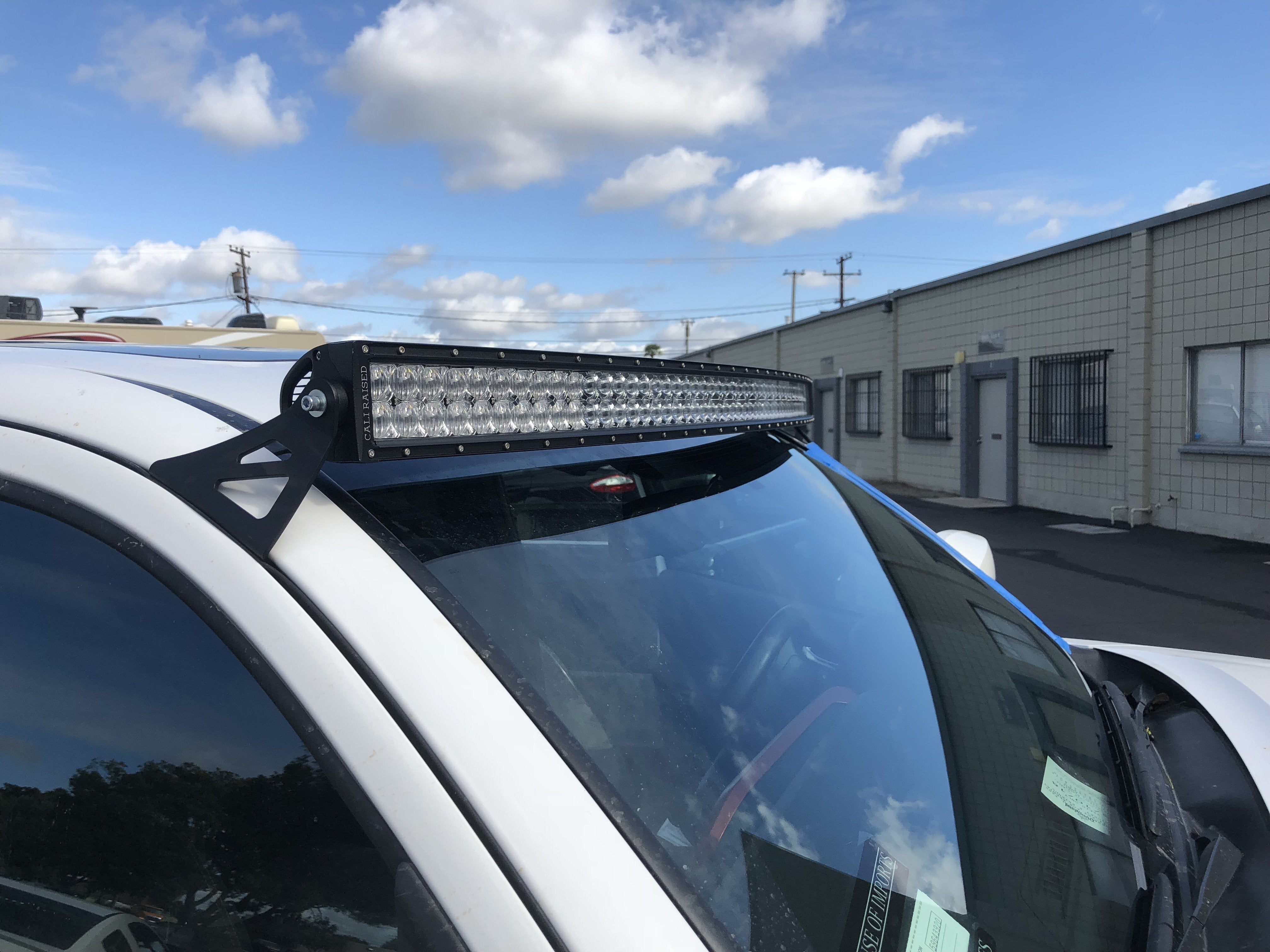 Off-road LED light bar mounted on a white vehicle roof, ideal for overlanding vehicles