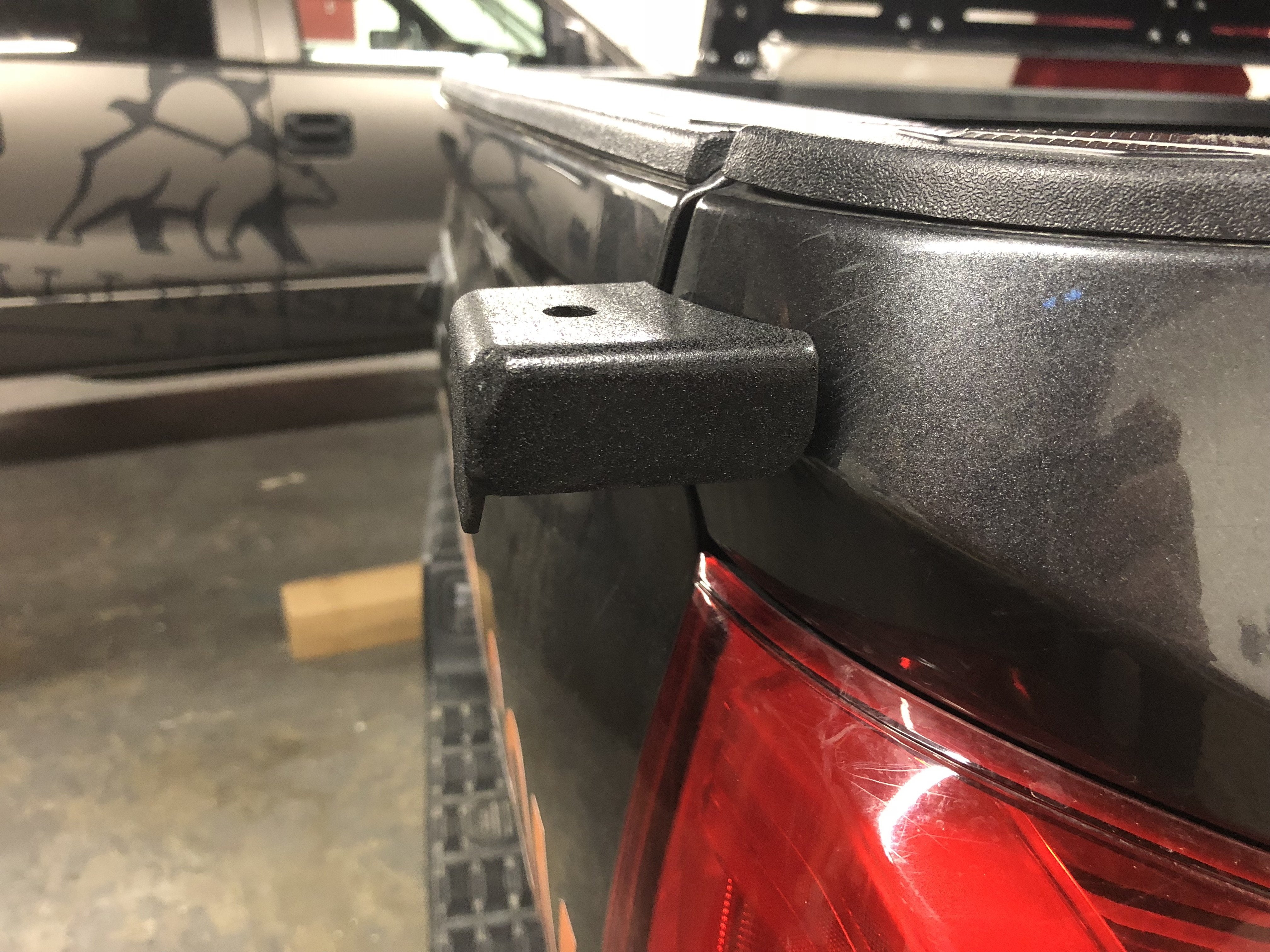 Truck bed rail accessory mount installed near tail light, ideal for overlanding gear setup
