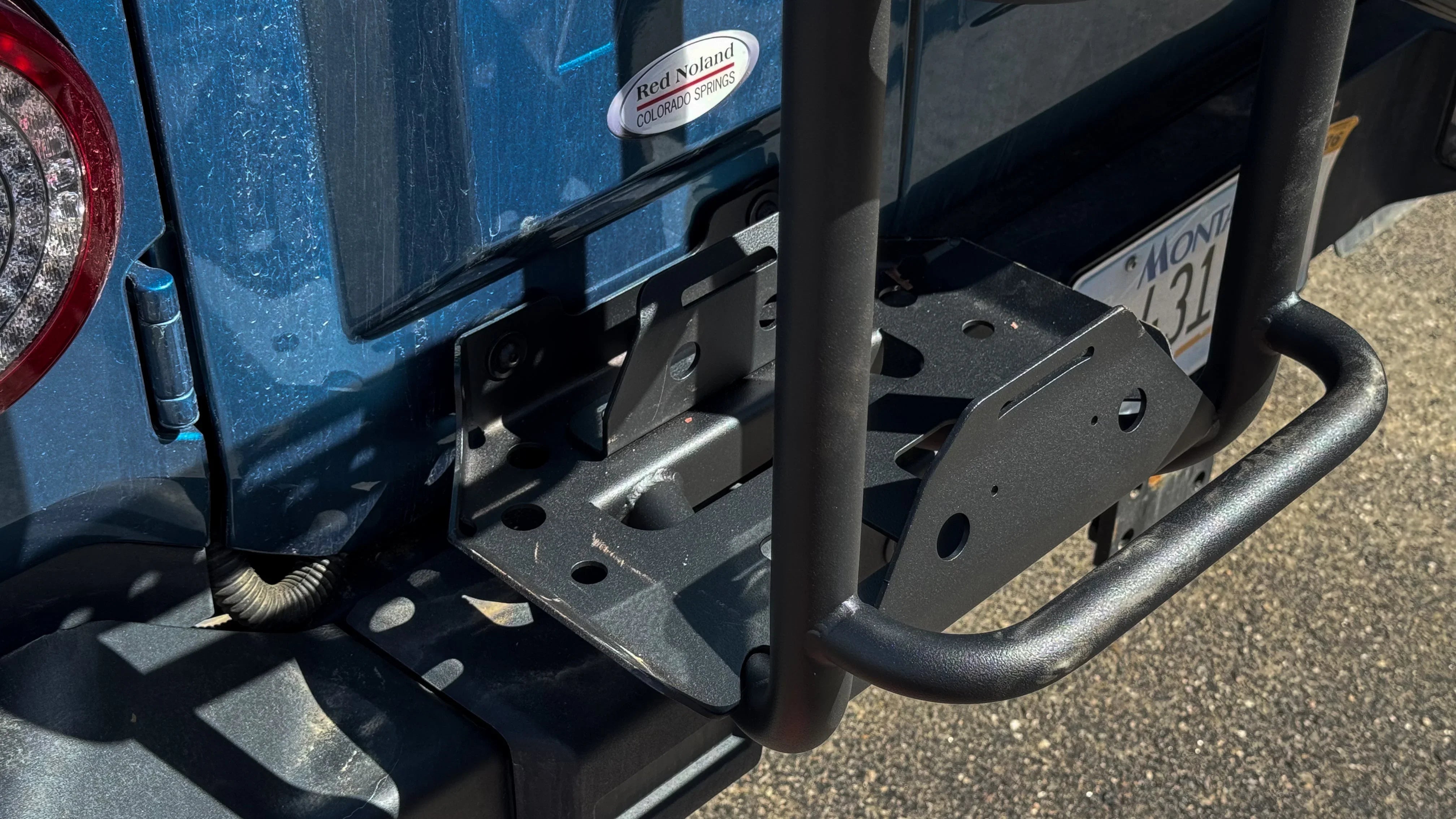 Close-up of integrated jerry can mount system on rear of off-road vehicle