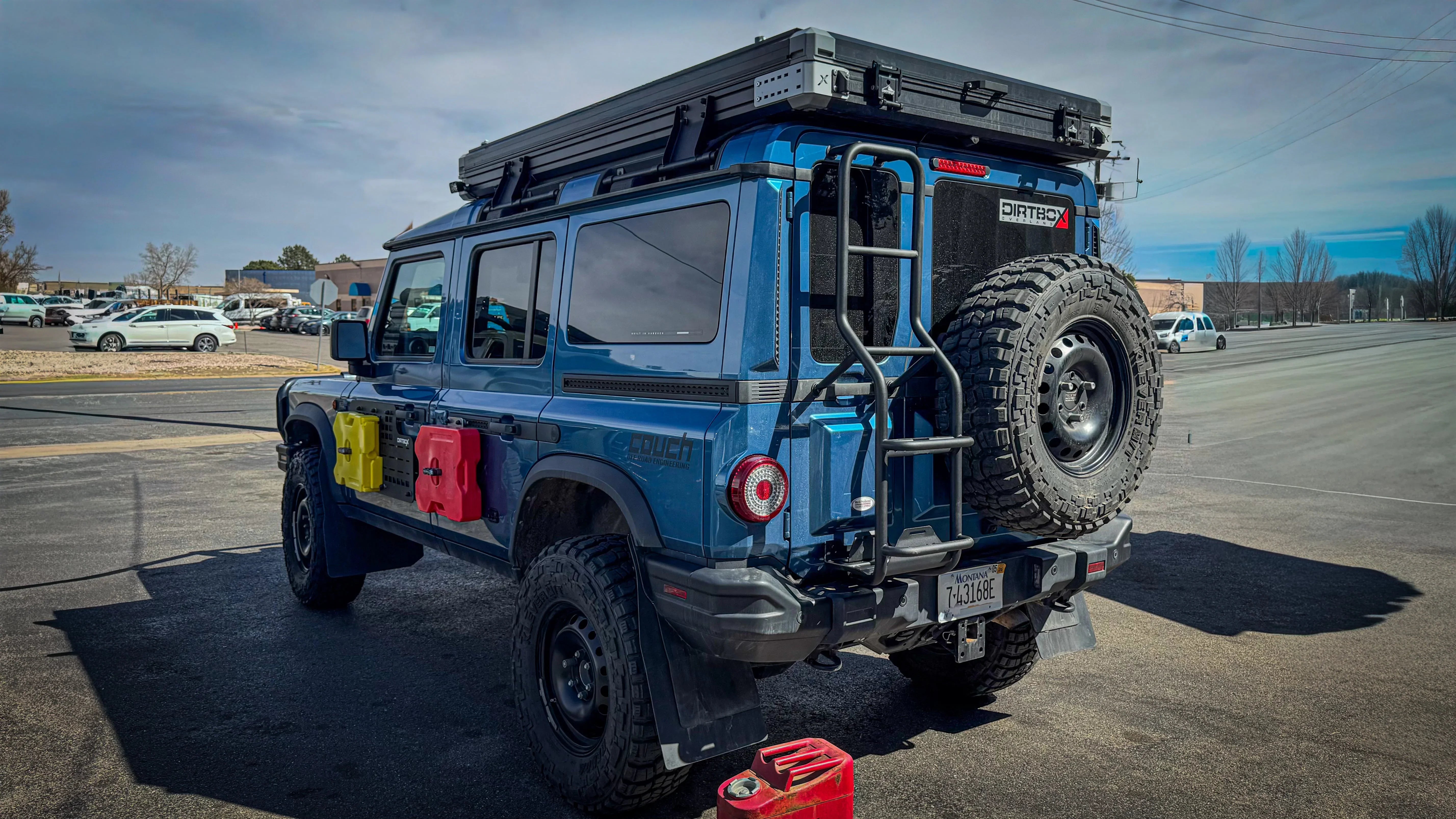 Ineos Grenadier with rear no-drill ladder, spare tire, roof rack, and expedition gear