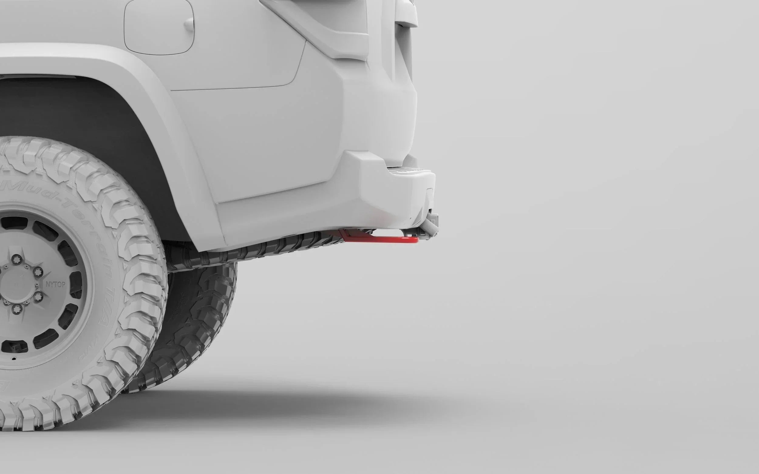 Off-road vehicle rear bumper with red recovery point and mud terrain tires