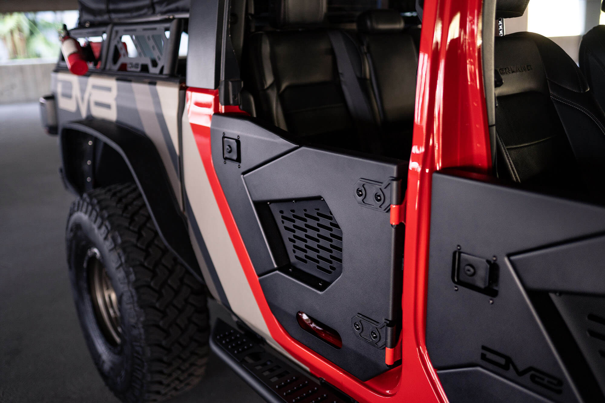Jeep Gladiator with black off-road half doors and rugged all-terrain tires in a garage