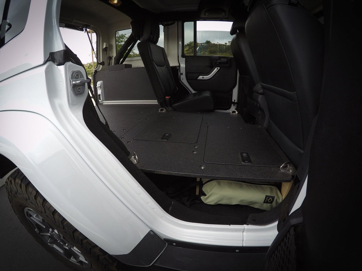 Goose Gear second row seat delete plate in a white Jeep Wrangler JKU, flat platform viewed from the rear door