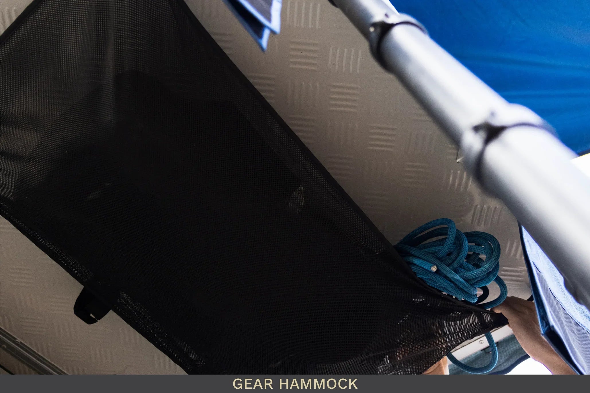 Mesh gear hammock for overlanding, holding blue rope in vehicle interior storage