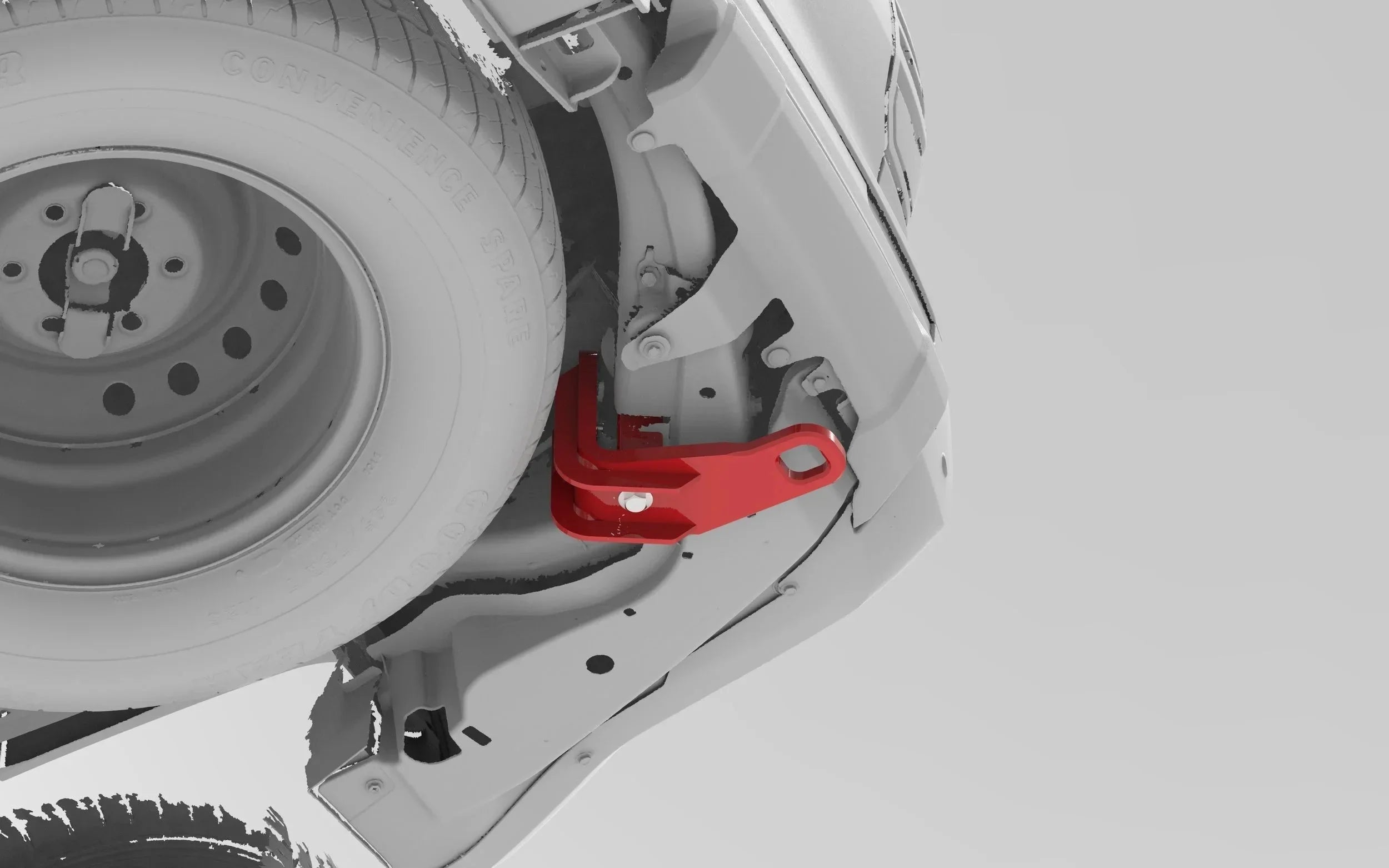 Red rear recovery point installed on vehicle frame near spare tire, overlanding accessory