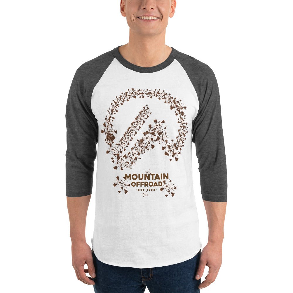 Man wearing white and gray raglan shirt with Mountain Offroad graphic and dirt splatter design