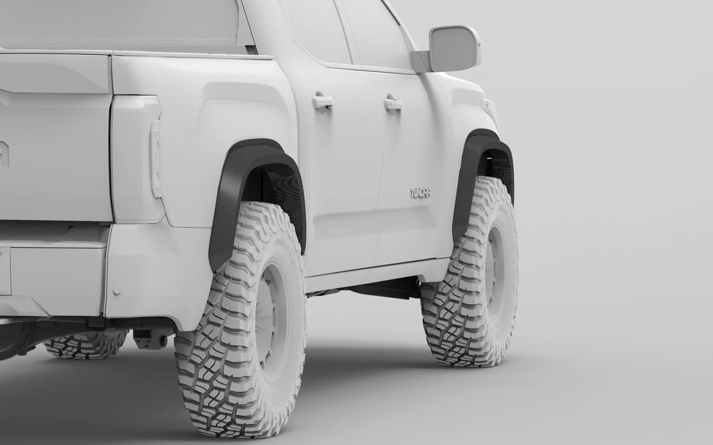Toyota Tundra truck with off-road tires and fender flares, side rear view