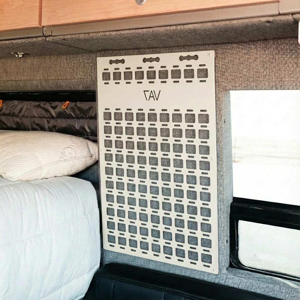Overland vehicle interior with modular gear panel mounted beside bed and window