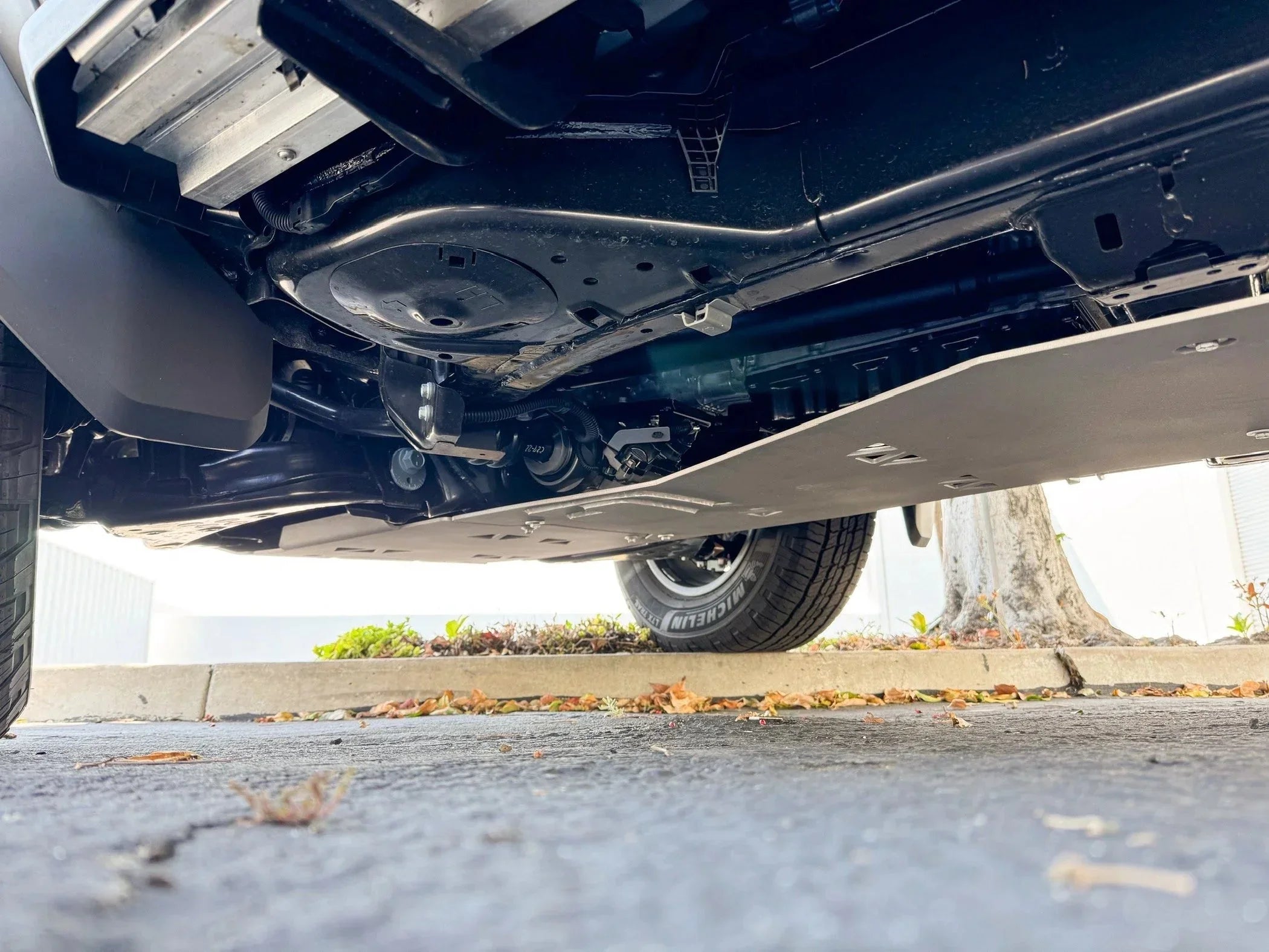 Underbody view of a truck with off-road skid plate and visible suspension system.
