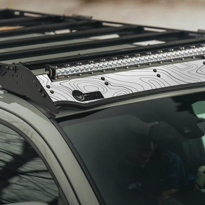 Overland roof rack with light bar and white topographic pattern panel on vehicle