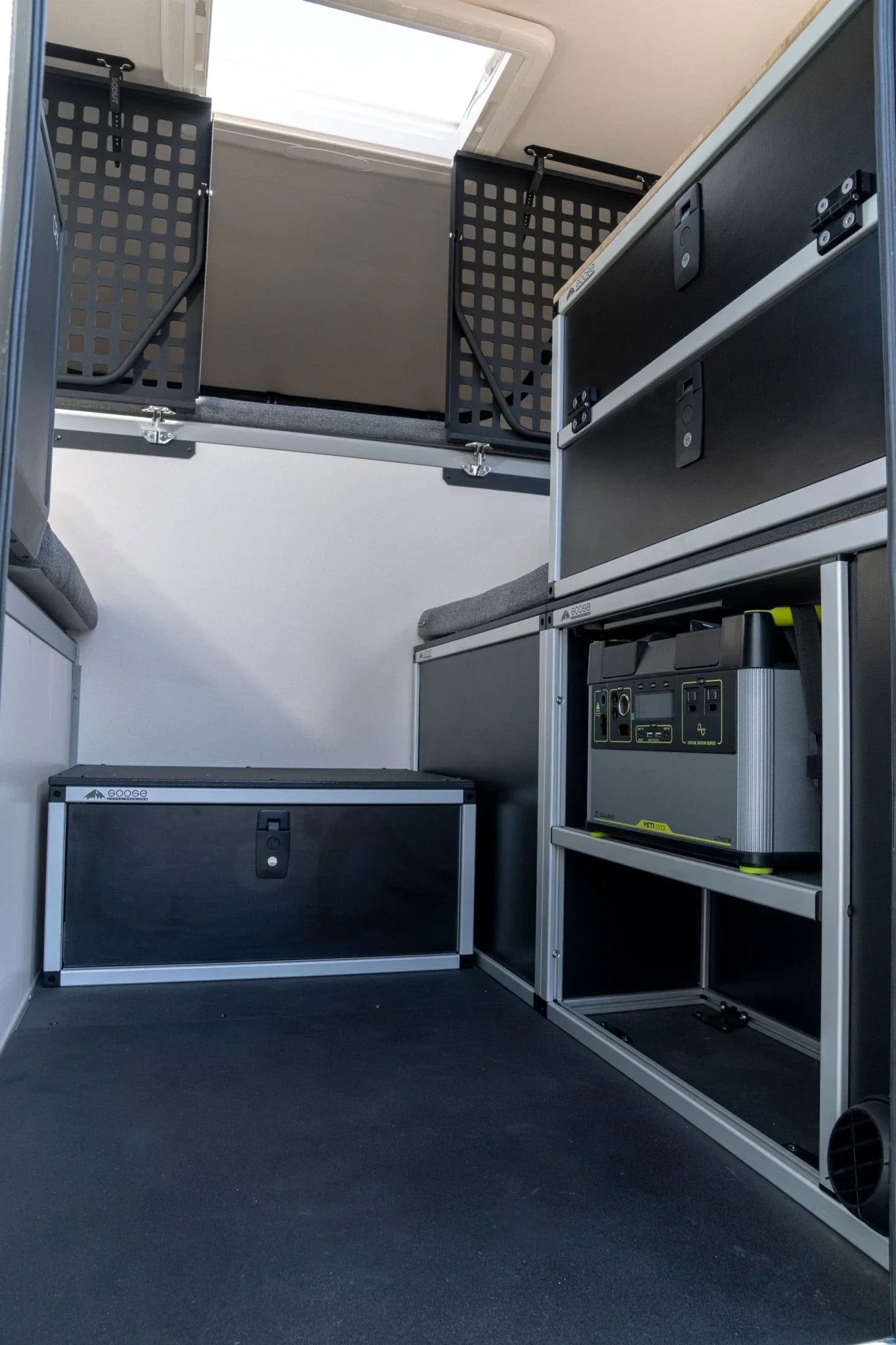 Overland vehicle interior with modular storage drawers, power station, and rooftop window