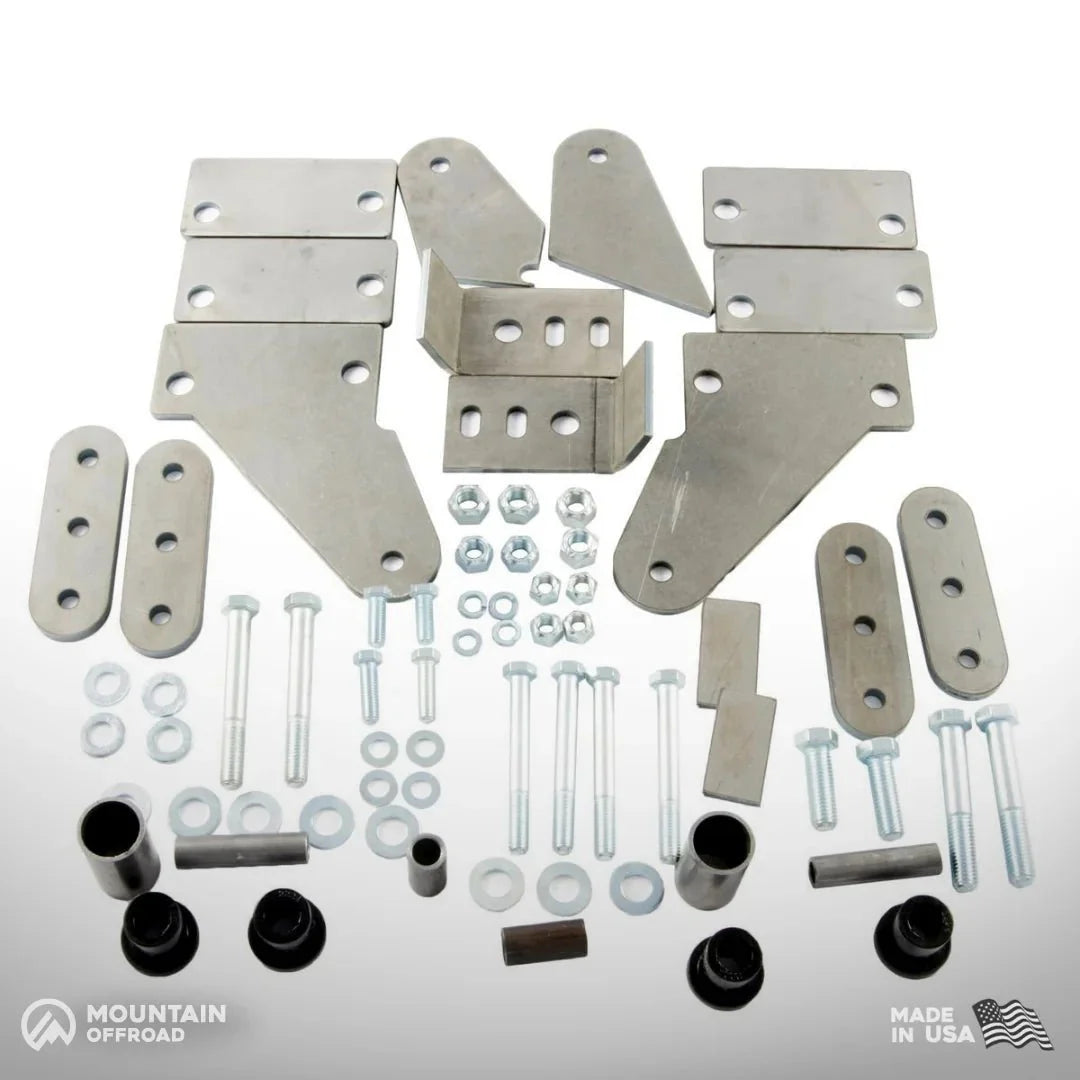 Jeep CJ shackle reversal system kit with metal brackets, bolts, washers, and bushings arranged on a white background.