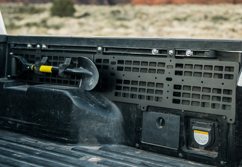 Toyota Tacoma bed molle panel with mounted off-road shovel, overlanding gear setup