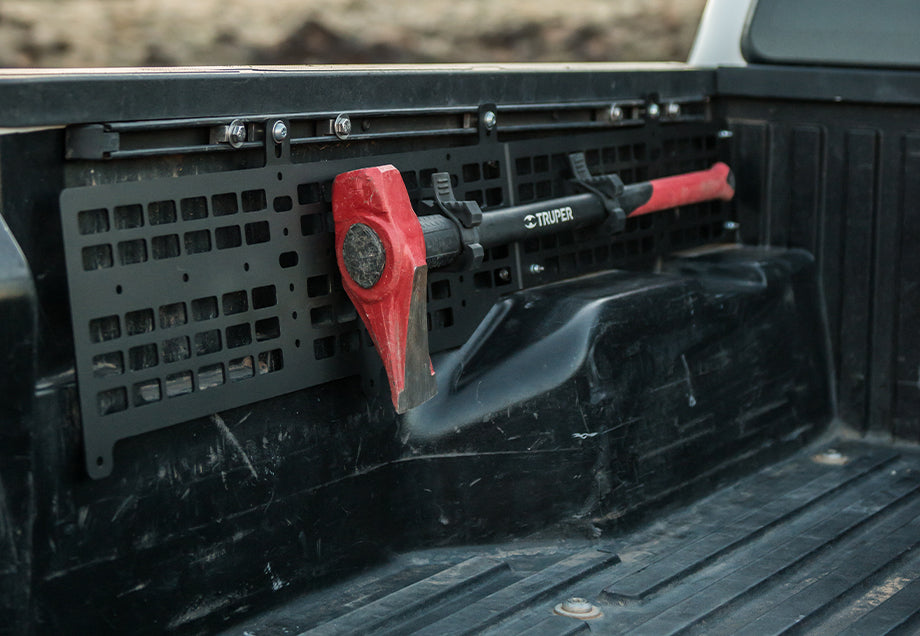 MOLLE panel mounted in Toyota Tacoma truck bed holding a red Truper axe for overlanding gear organization