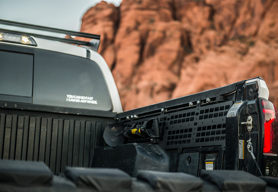 Toyota Tacoma truck bed with modular Molle panel storage system, outdoor desert backdrop