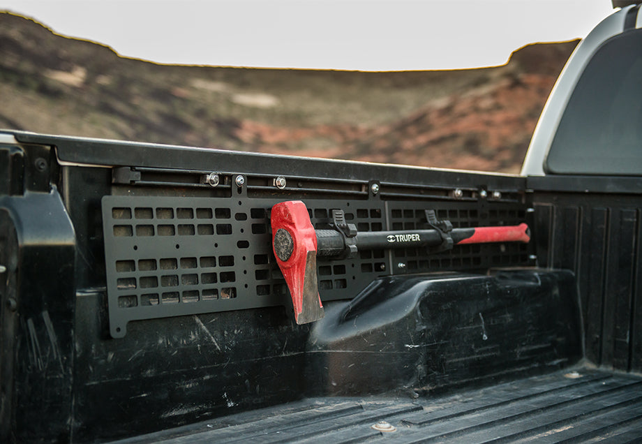 Toyota Tacoma bed with molle panel and mounted red axe for overlanding gear storage