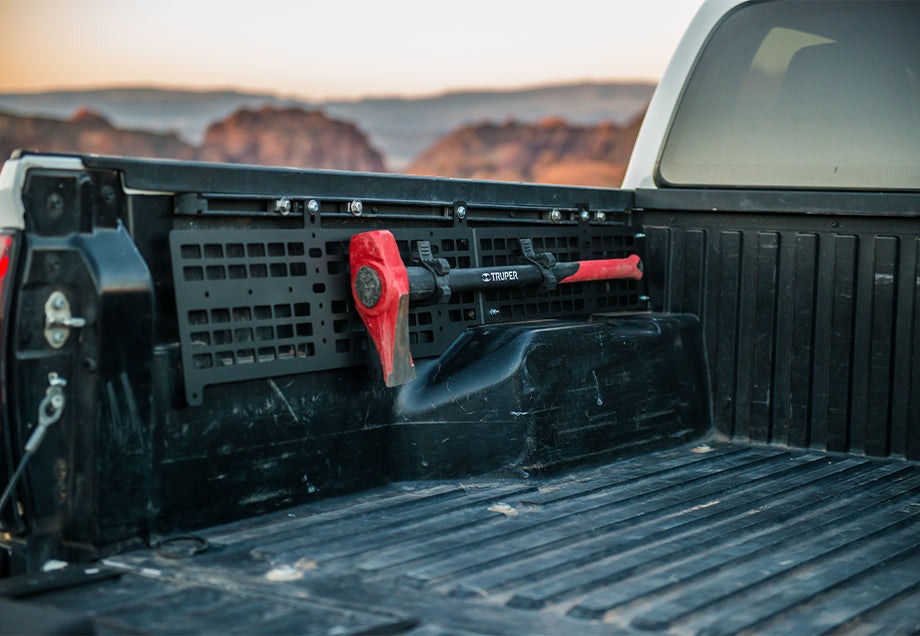 Toyota Tacoma truck bed with MOLLE panel and mounted Truper axe, outdoor camping gear