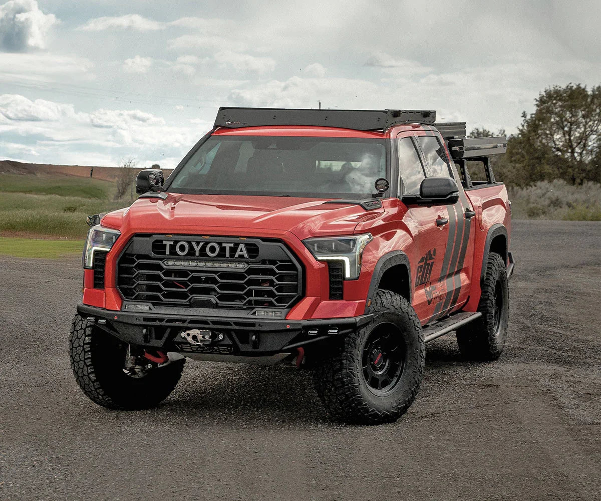 Red Toyota Tundra overland truck with off-road accessories parked outdoors