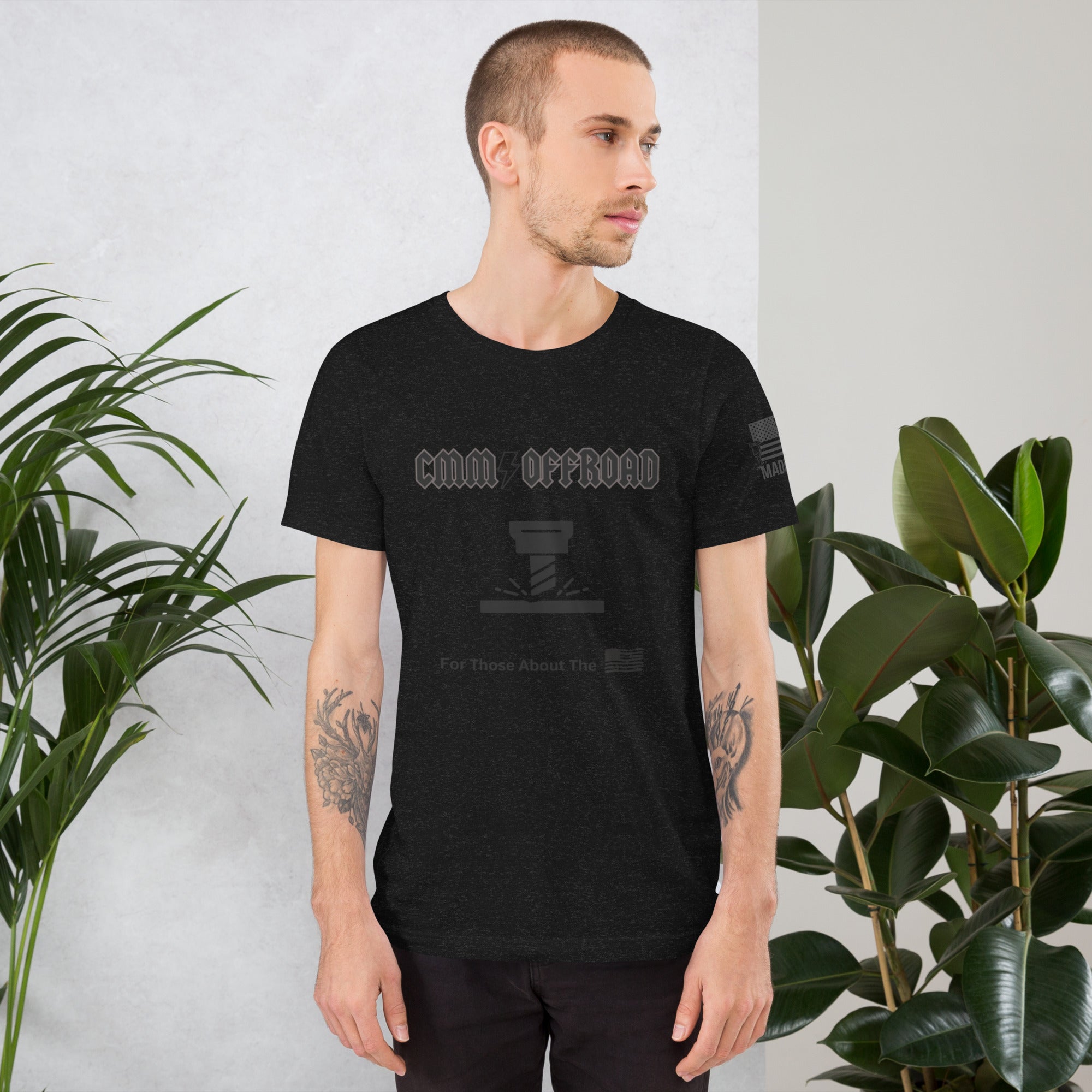 Man wearing black heather unisex offroad graphic t-shirt in casual indoor setting