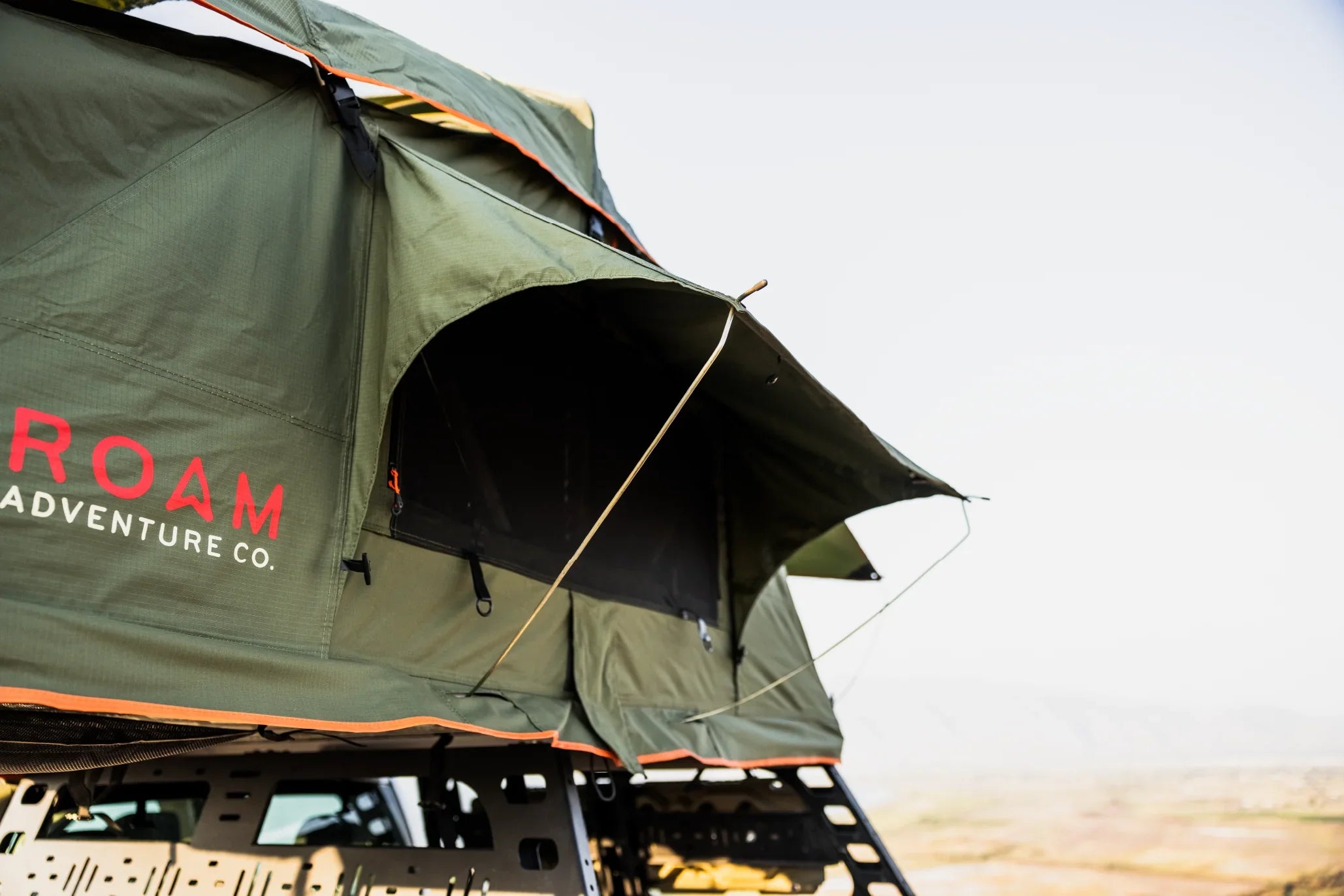 Green rooftop tent for overlanding on vehicle, outdoor adventure camping gear