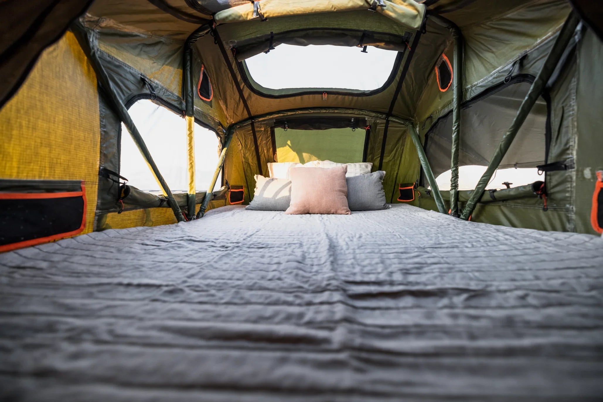 Spacious rooftop tent interior with bedding and pillows, ideal for overlanding and camping