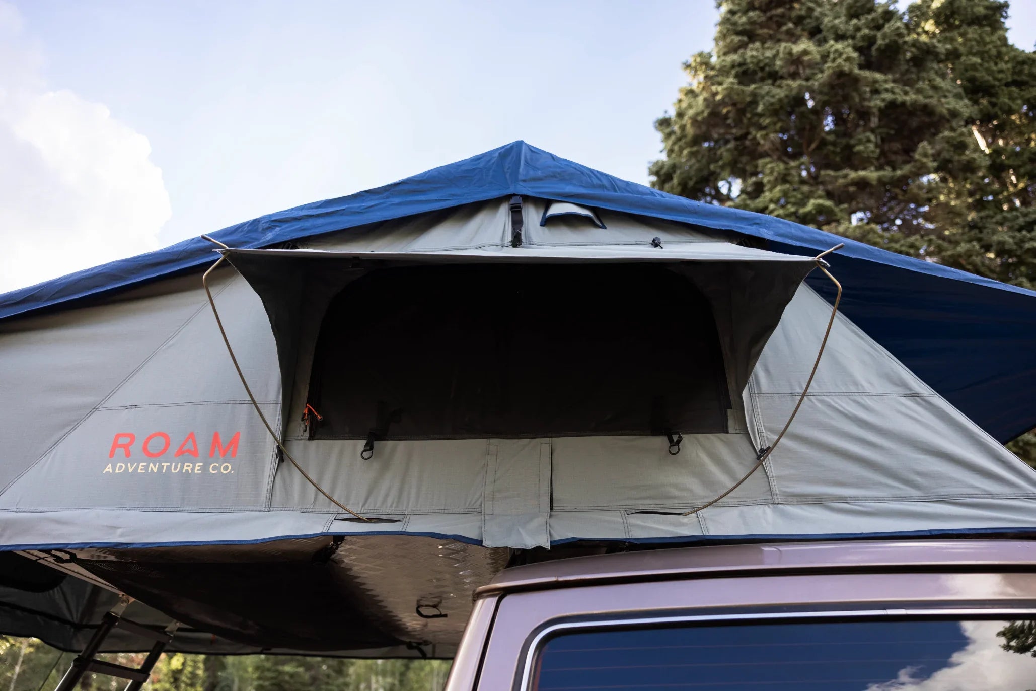 Roof top tent with open entrance mounted on a vehicle, ideal for overlanding camping