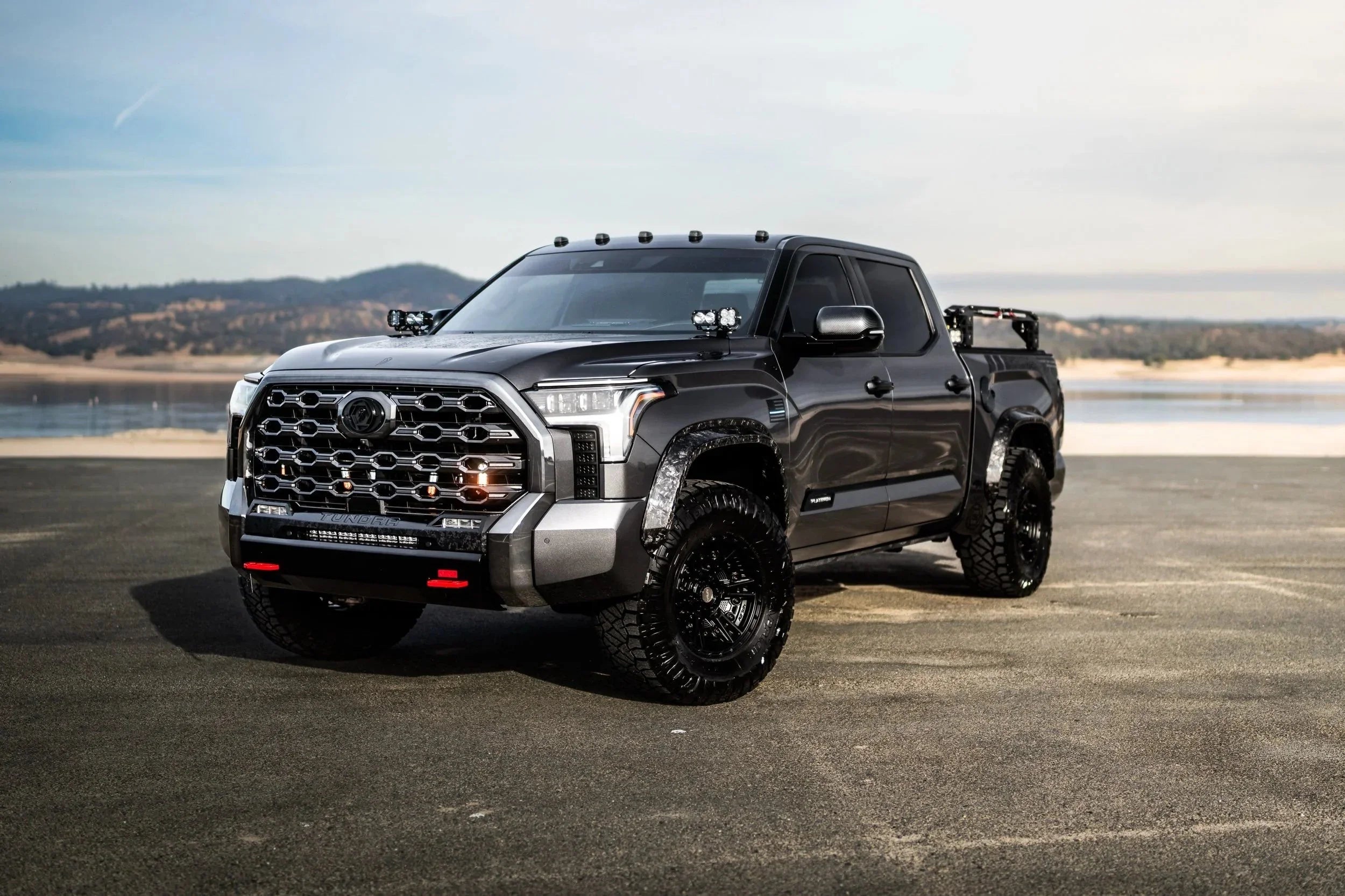 Lifted Toyota Tundra truck with off-road tires and aftermarket accessories on pavement