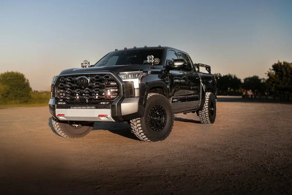 Black Toyota Tundra truck with off-road tires and adventure accessories parked outdoors
