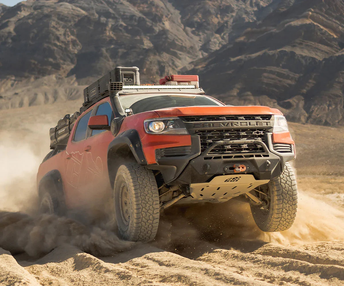Chevrolet off-road truck with expedition gear driving through desert terrain